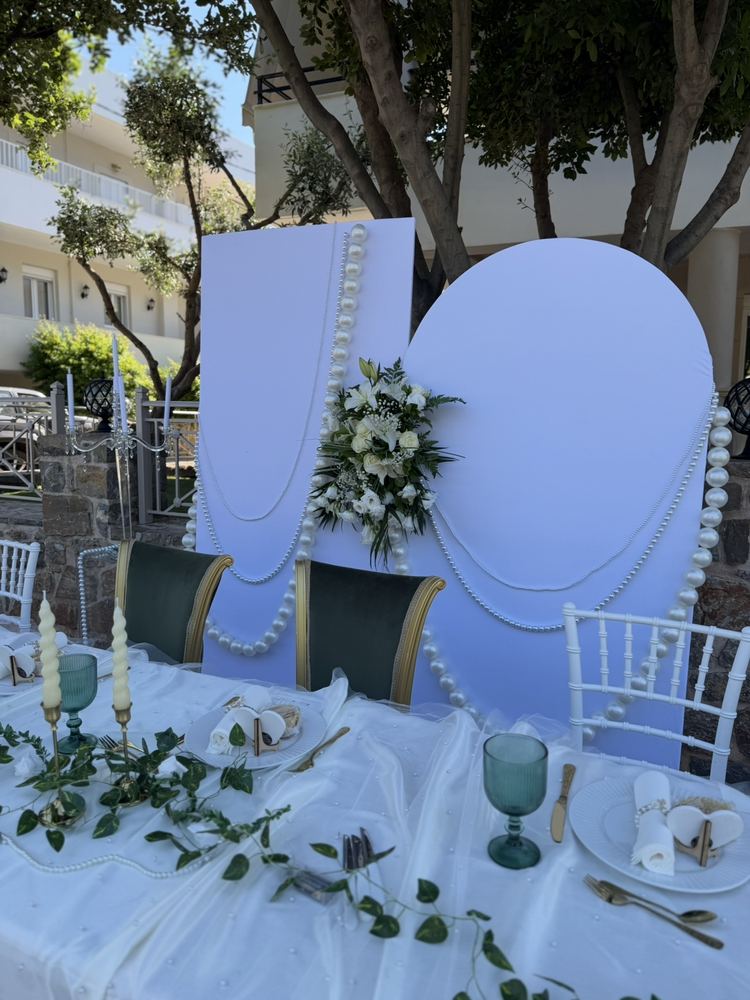 Λιλά backdrop με πέρλες στο τραπέζι των νεόνυμφων